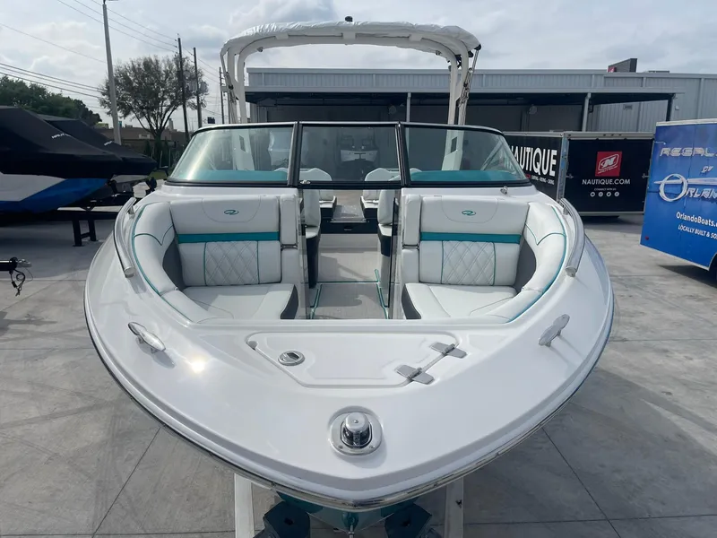 Slide: The Image of 2024 Regal LS4 boat, front view, white and teal interior, docked outdoors. - 4