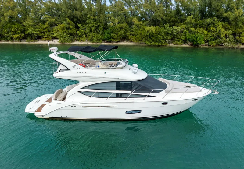 The Image of 2012 Meridian Sedan Bridge yacht on calm water with lush green shoreline. - 0