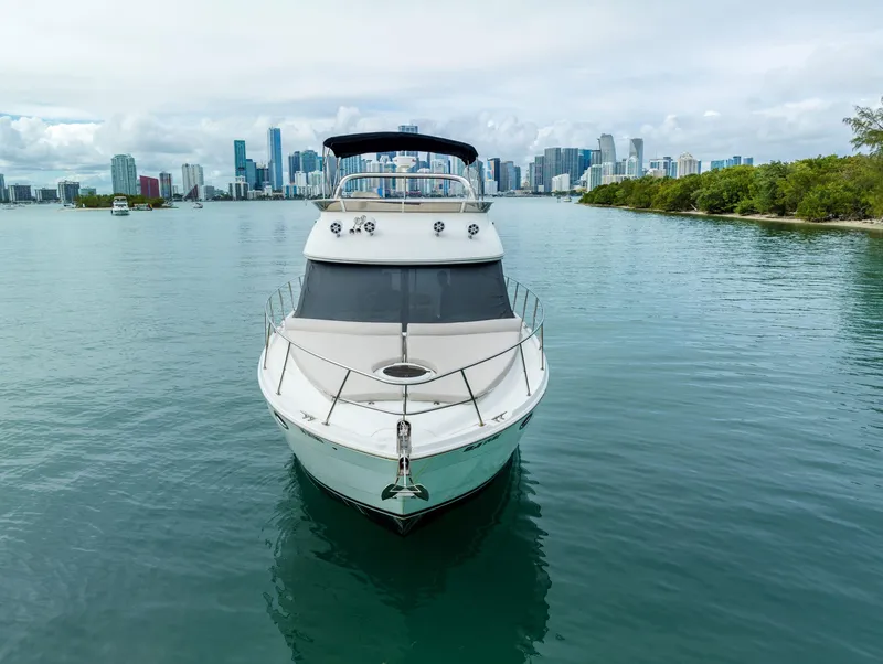 Slide: The Image of 2012 Meridian Sedan Bridge yacht on calm waters with city skyline background. - 14