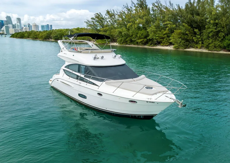 Slide: The Image of 2012 Meridian Sedan Bridge yacht cruising in clear waters near a lush shoreline. - 2