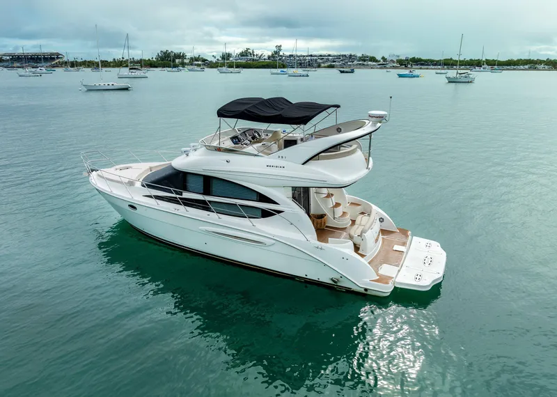 Slide: The Image of 2012 Meridian Sedan Bridge yacht on calm waters with other boats in the background. - 6
