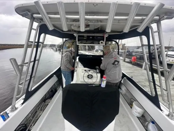 Slide: The Image of Two people working on a 1968 Wahoo Alglas 25 boat at a dock. - 10