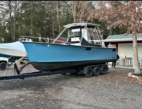 Slide: The Image of 1968 Wahoo Alglas 25 boat on a trailer in a wooded area. - 2