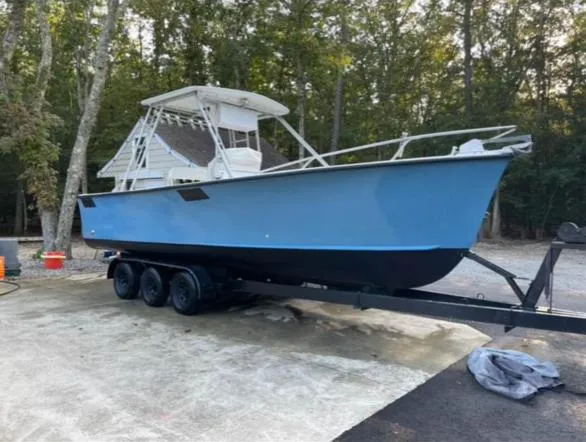 Slide: The Image of 1968 Wahoo Alglas 25 boat on a trailer in a wooded area. - 3