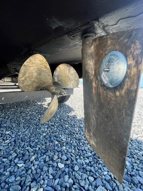 Slide: The Image of Close-up of 1968 Wahoo Alglas 25 boat propeller and rudder on gravel. - 48