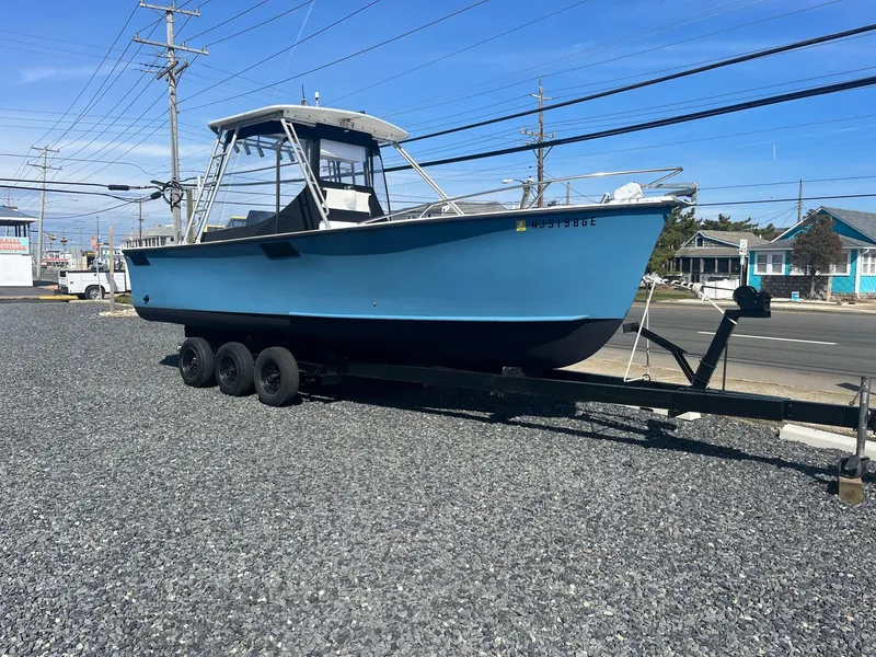Slide: The Image of 1968 Wahoo Alglas 25 boat on a trailer in a gravel lot. - 5