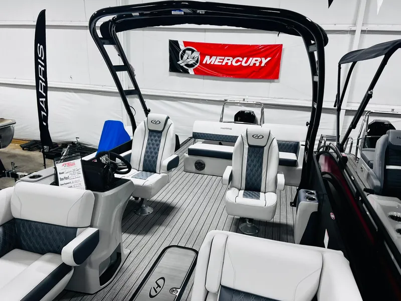 Slide: The Image of 2024 Harris Sunliner 250 Sport pontoon boat interior with Mercury engine banner. - 10
