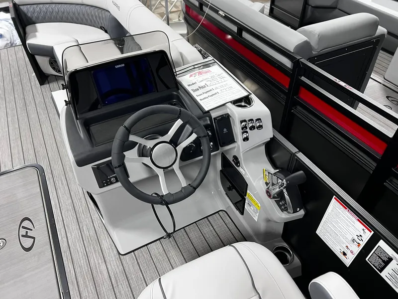 Slide: The Image of 2024 Harris Sunliner 250 Sport boat cockpit with steering wheel and control panel. - 12