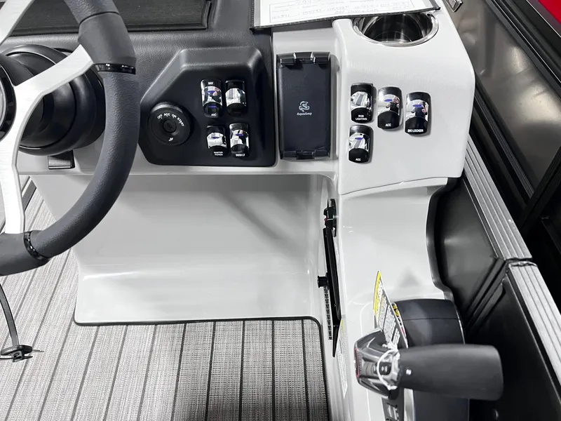 Slide: The Image of 2024 Harris Sunliner 250 Sport boat dashboard with steering wheel and control panel. - 14