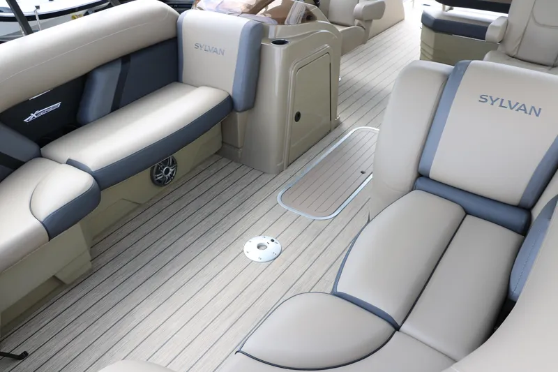 Slide: The Image of 2025 Sylvan Mirage X3 CLZ DH boat interior with beige and gray seating, spacious layout. - 18