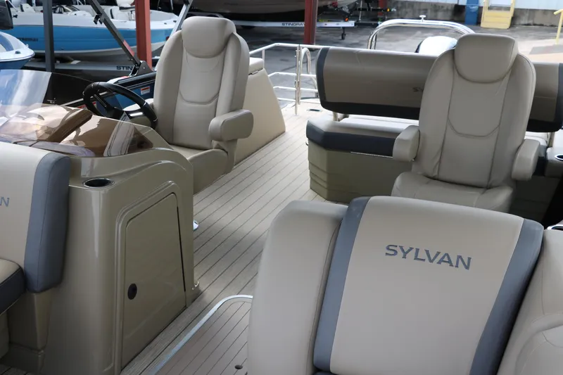Slide: The Image of 2025 Sylvan Mirage X3 CLZ DH pontoon boat interior with luxurious seating and steering console. - 19