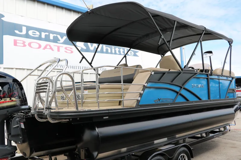 Slide: The Image of 2025 Sylvan Mirage X3 CLZ DH pontoon boat with blue exterior at dealership. - 2