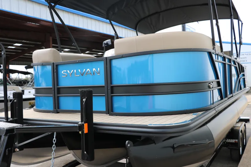 Slide: The Image of 2025 Sylvan Mirage X3 CLZ DH pontoon boat with blue exterior and beige seating. - 8