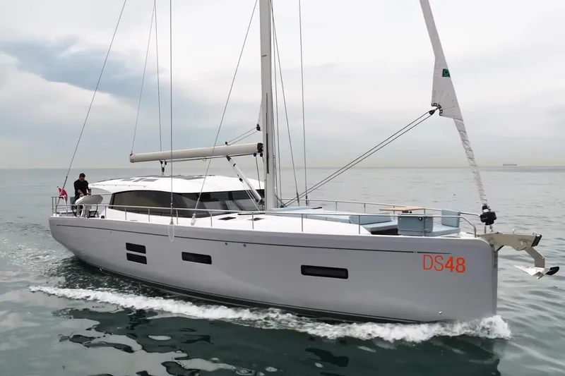 Slide: The Image of 2026 Moody 48 Deck Saloon yacht sailing on calm waters under a cloudy sky. - 32