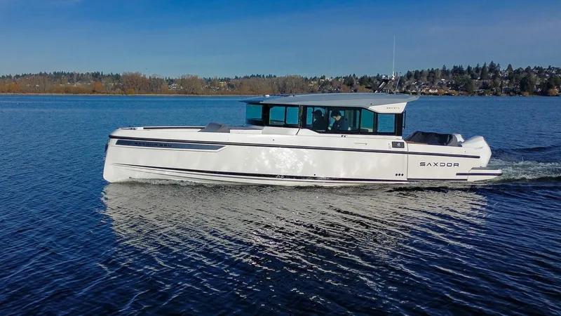 The Image of 2025 Saxdor 320 GTC cruising on a calm lake under a clear blue sky. - 0