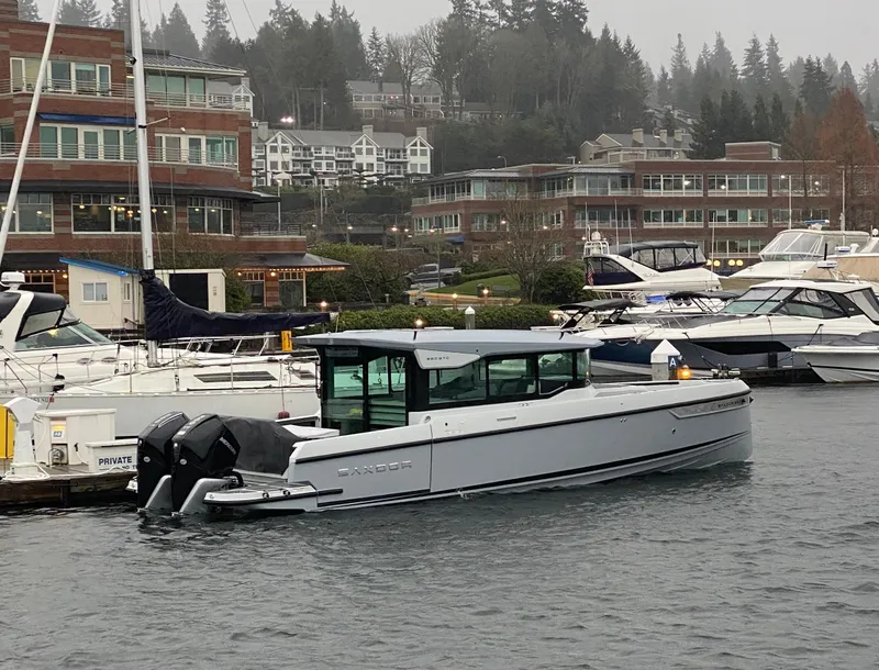 Slide: The Image of 2025 Saxdor 320 GTC boat docked in a marina on a cloudy day. - 2