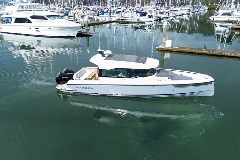 Slide: The Image of 2026 Saxdor 320 GTC boat cruising in a marina with yachts in the background. - 21