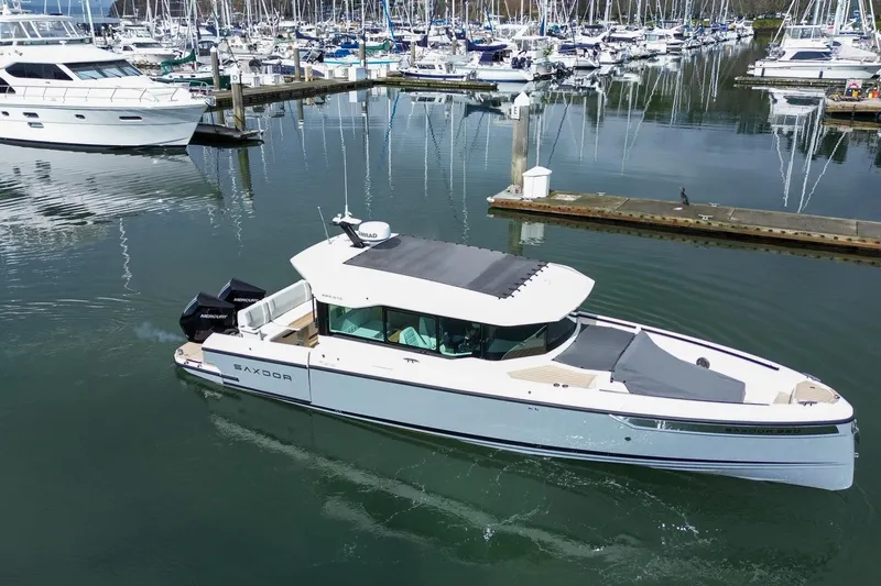 Slide: The Image of 2026 Saxdor 320 GTC boat docked in a marina with other vessels. - 22