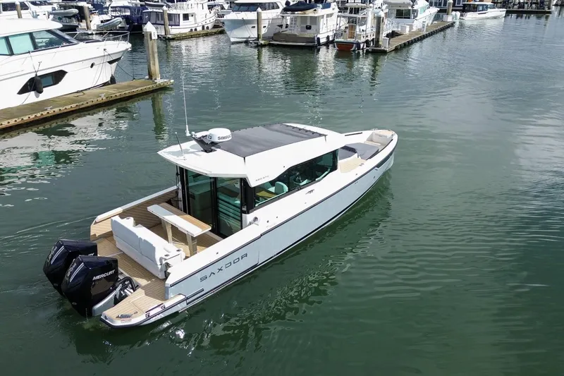 Slide: The Image of 2026 Saxdor 320 GTC boat docked in marina, featuring sleek design and dual Mercury engines. - 24