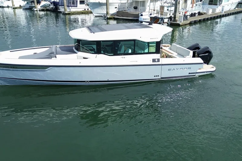 Slide: The Image of 2026 Saxdor 320 GTC boat docked in marina, featuring sleek design and twin Mercury engines. - 29