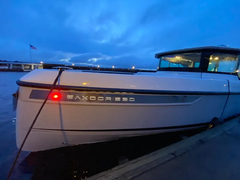 Slide: The Image of 2025 Saxdor 320 GTC boat docked at twilight with illuminated nameplate. - 3