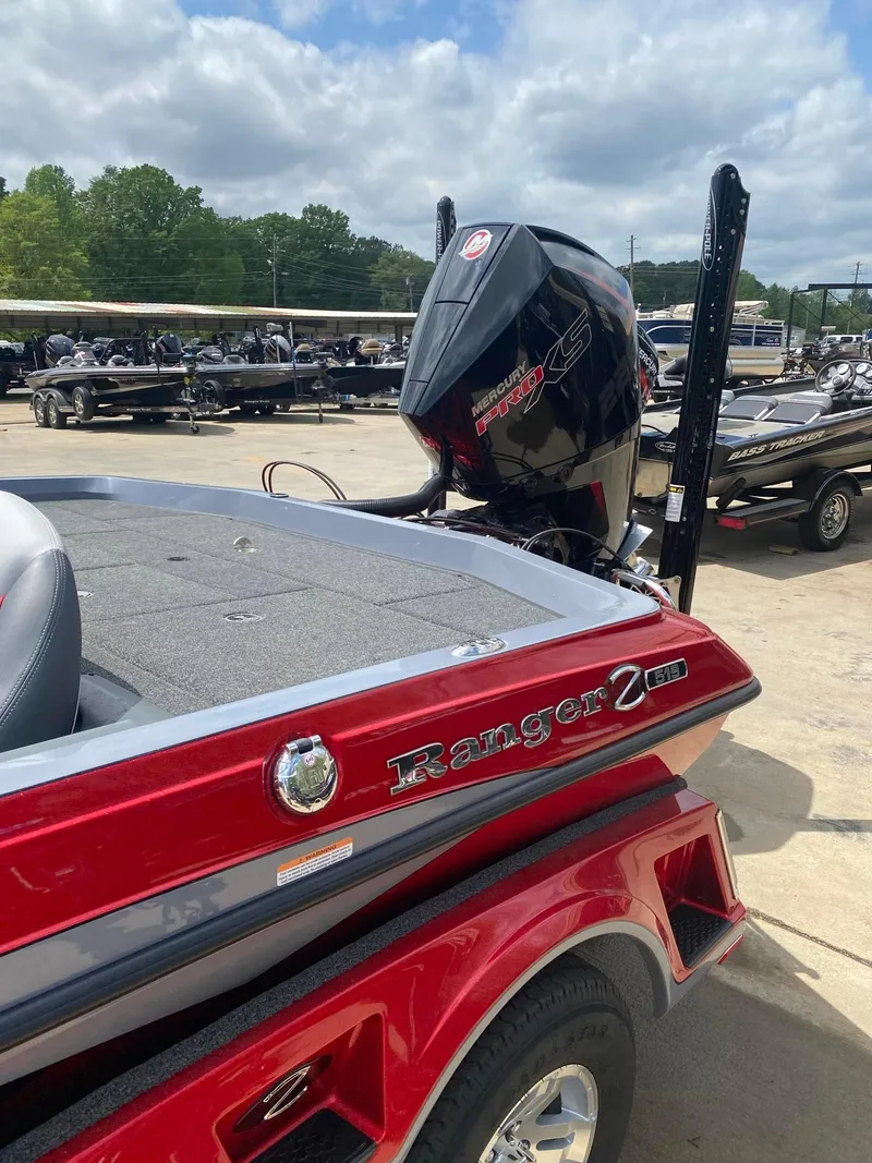 Slide: The Image of 2024 Ranger Z519 Ranger Cup Equipped boat, red and black, parked outdoors. - 4