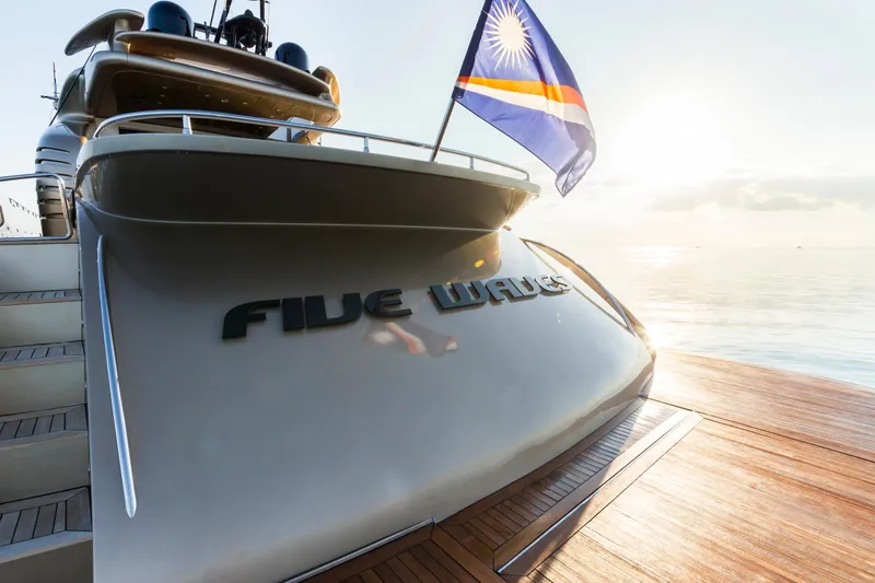 Slide: The Image of Luxury yacht "Five Waves" docked, featuring AB 118 model, 2010, with a flag at sunset. - 24