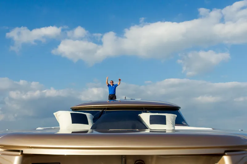 Slide: The Image of Person celebrating on AB 118 yacht, 2010 model, under a blue sky with clouds. - 39