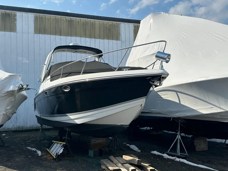 The Image of 2007 Formula 27 PC boat in storage, black and white hull, covered boats nearby. - 1