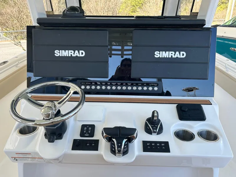 Slide: The Image of 2024 Sea Pro 322 Offshore boat dashboard with dual Simrad displays and steering wheel. - 22