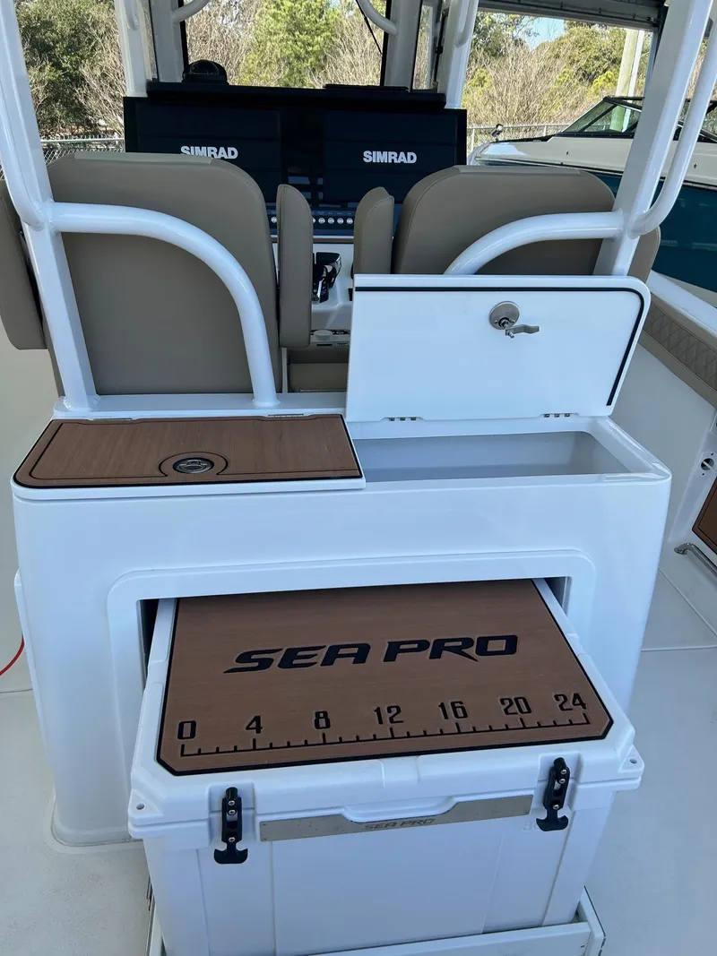 Slide: The Image of 2024 Sea Pro 322 Offshore boat interior with Simrad electronics and storage compartments. - 24