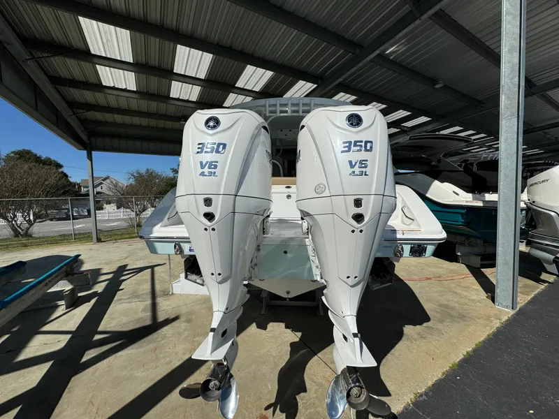 Slide: The Image of 2024 Sea Pro 322 Offshore with twin 350 V6 outboard engines under a covered dock. - 6