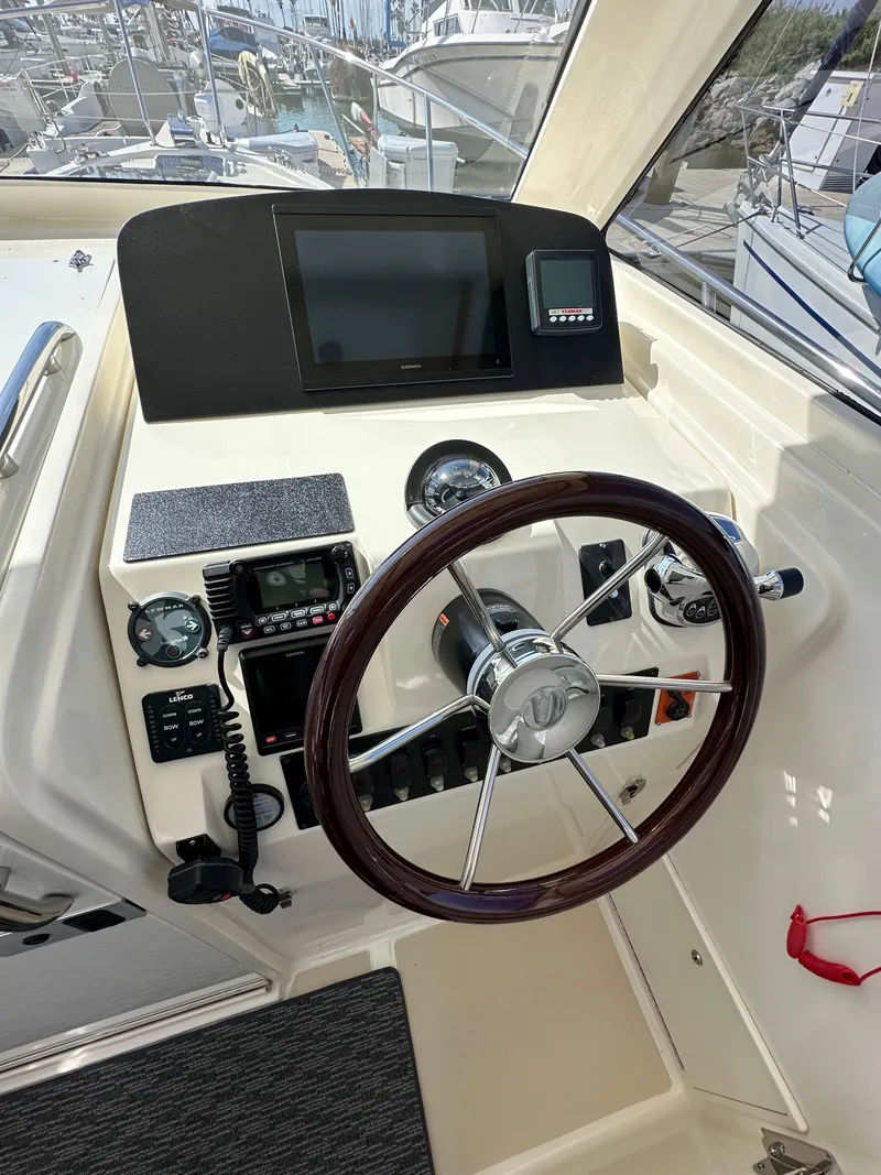 Slide: The Image of Helm station of a 2016 Marlow Pilot 31 boat with steering wheel and navigation equipment. - 16