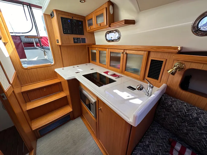 Slide: The Image of Modern galley kitchen in 2016 Marlow Pilot 31 boat with wood cabinetry and white countertops. - 21