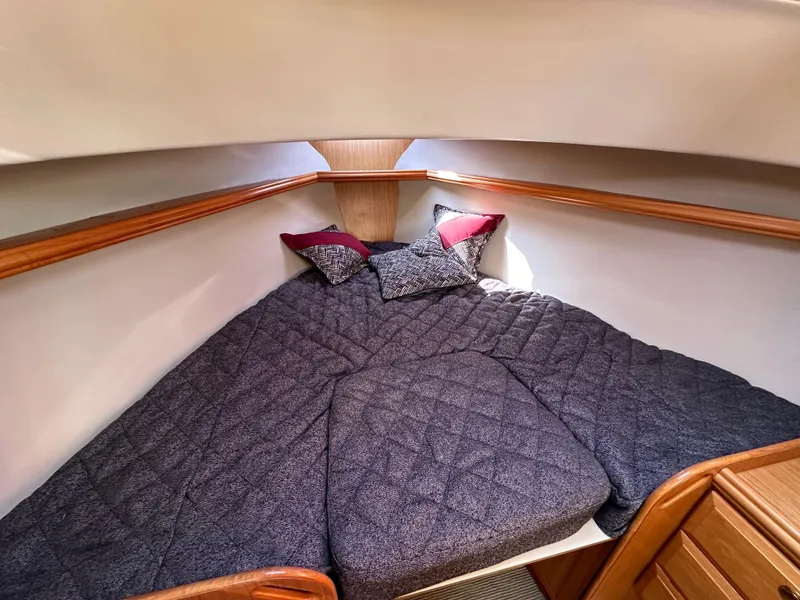 Slide: The Image of Cozy cabin bed in a 2016 Marlow Pilot 31 boat with plush bedding and pillows. - 24