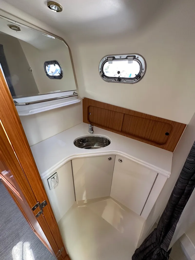 Slide: The Image of 2016 Marlow Pilot 31 boat bathroom with sink and mirror. - 26