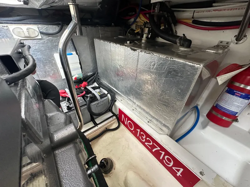 Slide: The Image of Engine compartment of a 2016 Marlow Pilot 31 boat with battery and fire extinguisher. - 32