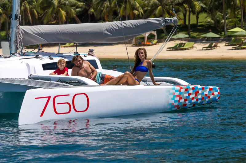 Slide: The Image of Family enjoying a day on a 2026 Corsair 760 sailboat near a tropical beach. - 15