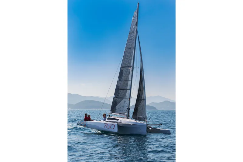 Slide: The Image of Sleek 2026 Corsair 760 sailboat gliding on open water under clear blue skies. - 18