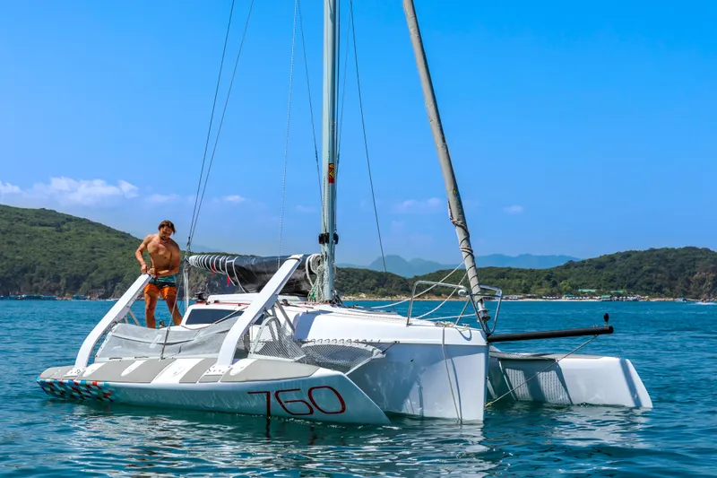 Slide: The Image of Man sailing on a 2026 Corsair 760 trimaran in clear blue waters. - 41