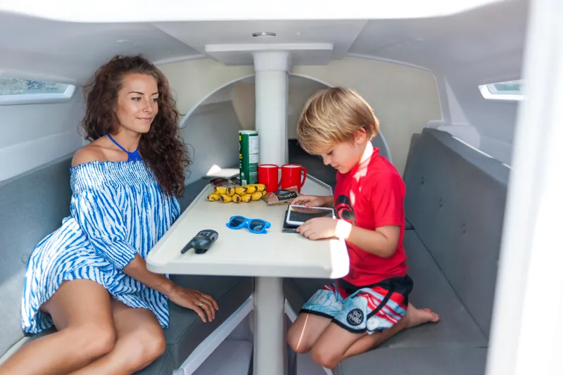 Slide: The Image of Family enjoying leisure time inside a 2026 Corsair 760 sailboat cabin. - 6