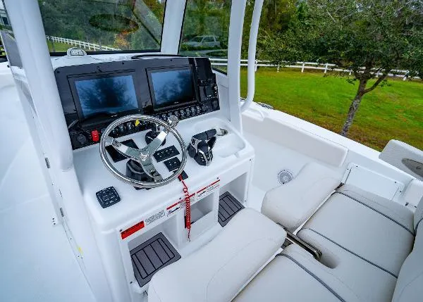 Slide: The Image of 2023 Sea Hunt Gamefish 27 boat cockpit with dual screens and steering wheel. - 14