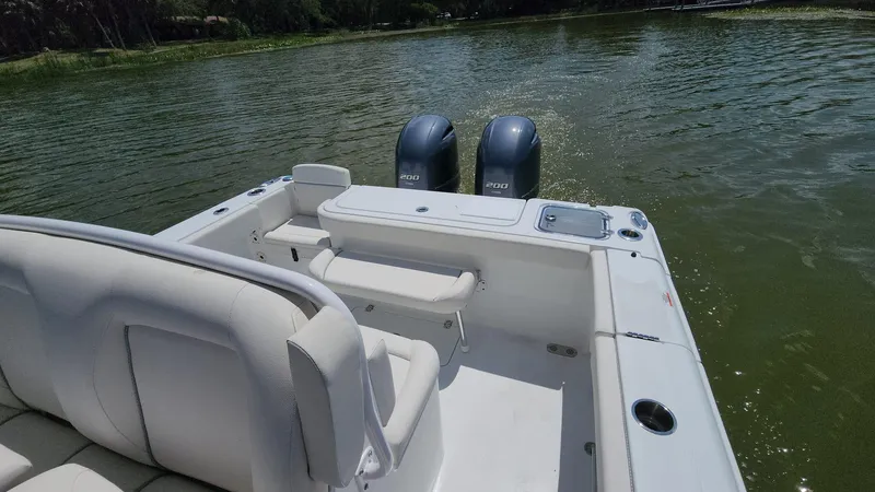 Slide: The Image of 2023 Sea Hunt Gamefish 27 boat with twin outboard motors on a lake. - 2