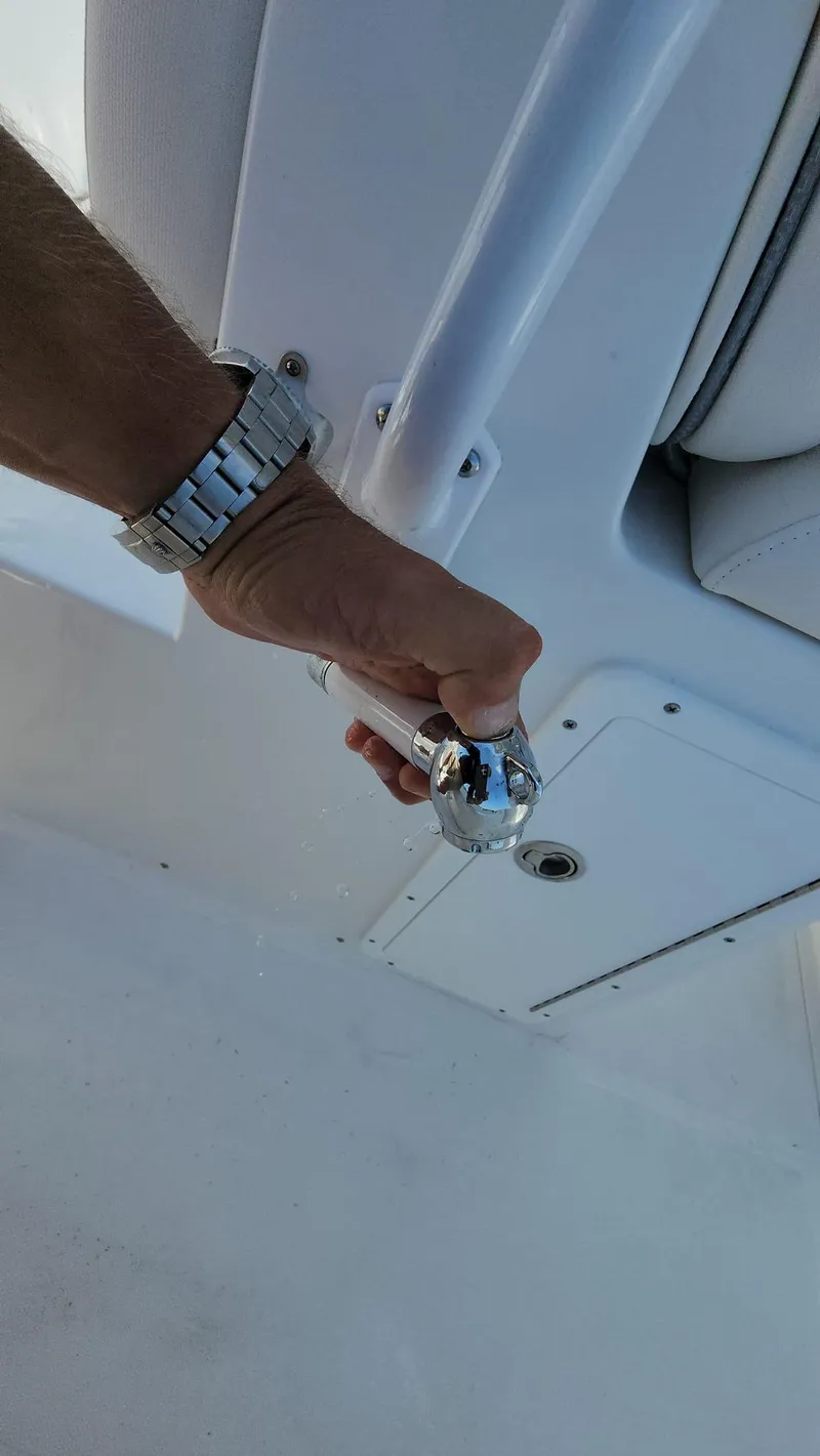 Slide: The Image of Hand operating a control lever on a 2023 Sea Hunt Gamefish 27 boat. - 39