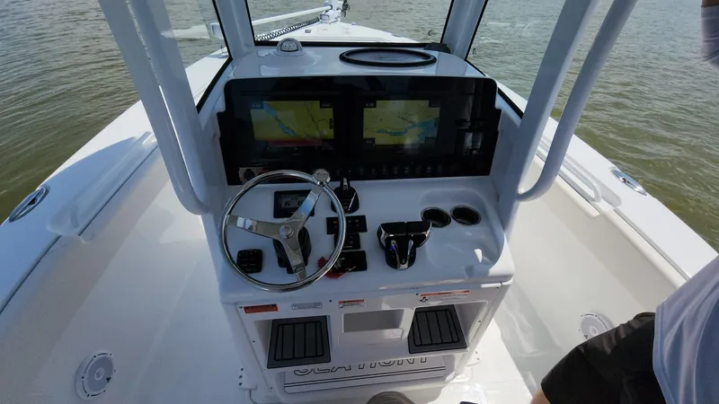 Slide: The Image of 2023 Sea Hunt Gamefish 27 boat console with dual navigation screens and steering wheel. - 5