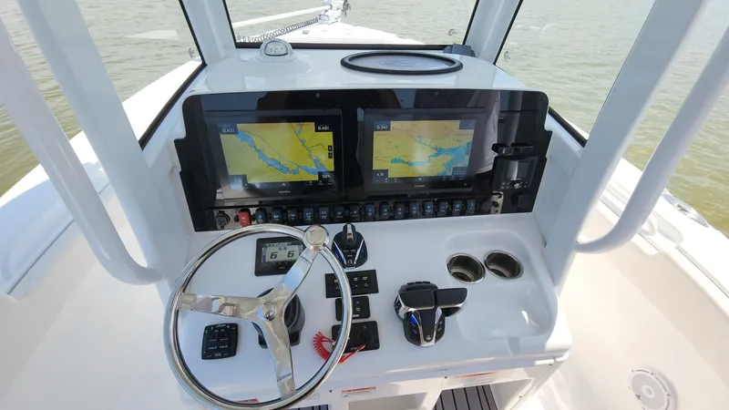 Slide: The Image of 2023 Sea Hunt Gamefish 27 helm with dual navigation screens and steering wheel. - 8