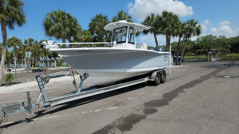Slide: The Image of 2023 Sea Hunt Gamefish 27 boat on trailer in sunny parking lot with palm trees. - 9