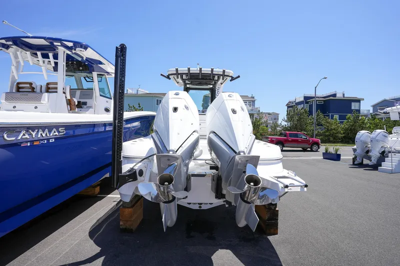 Slide: The Image of 2024 Caymas 281 HB boat with dual outboard engines, docked on a sunny day. - 12