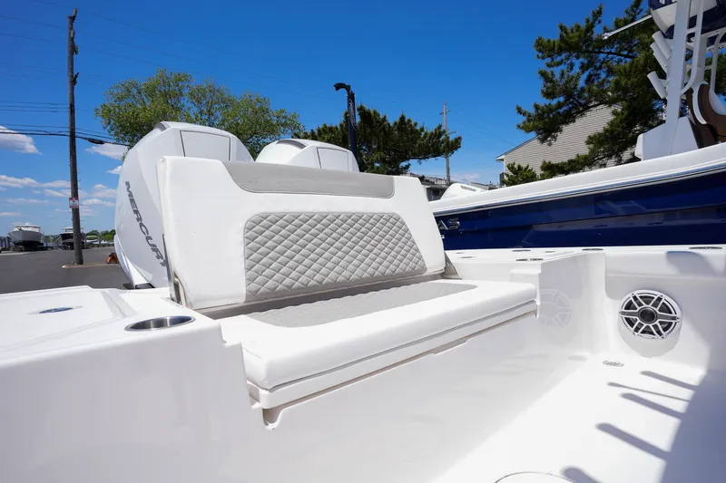 Slide: The Image of 2024 Caymas 281 HB boat with cushioned seating and dual outboard motors. - 15