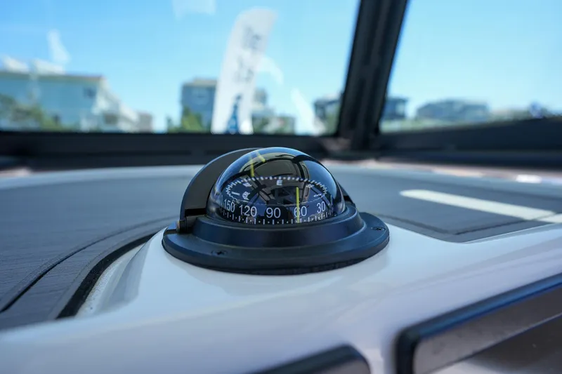 Slide: The Image of Close-up of compass on 2024 Caymas 281 HB boat dashboard. - 21